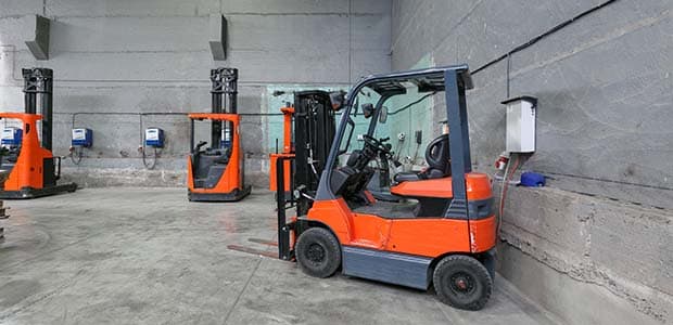 Electric forklifts recharge in a factory.