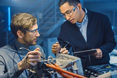 Automobilingenieure arbeiten im Forschungslabor an einem EV-Batterieverbindungssystem.